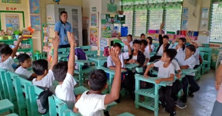 Students and their teacher inside a classroom.