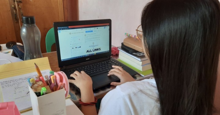 A student attending her online class at home.