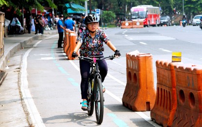 A young woman uses the bike lane along Elliptical Road in Quezon City