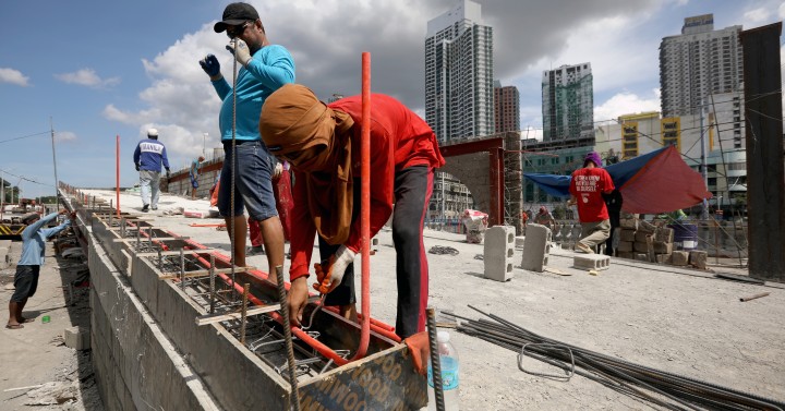 Workers install steel bars at a construction site